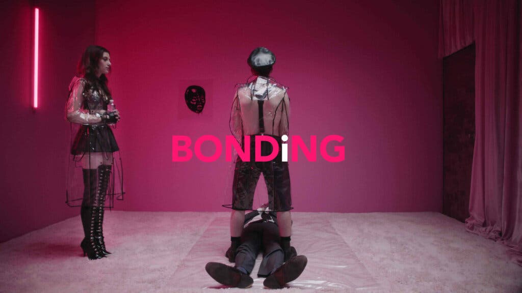 Tres personas con ropa de cuero en una habitación rosa en Bonding (Netflix)